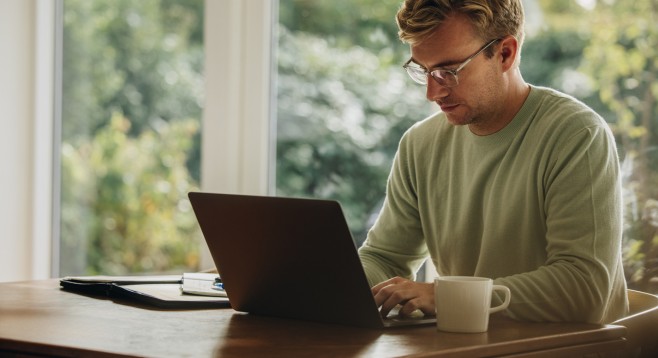 Mann sitzt am Laptop und richtet seine eigene E-Mail-Domain bei mailbox.org ein