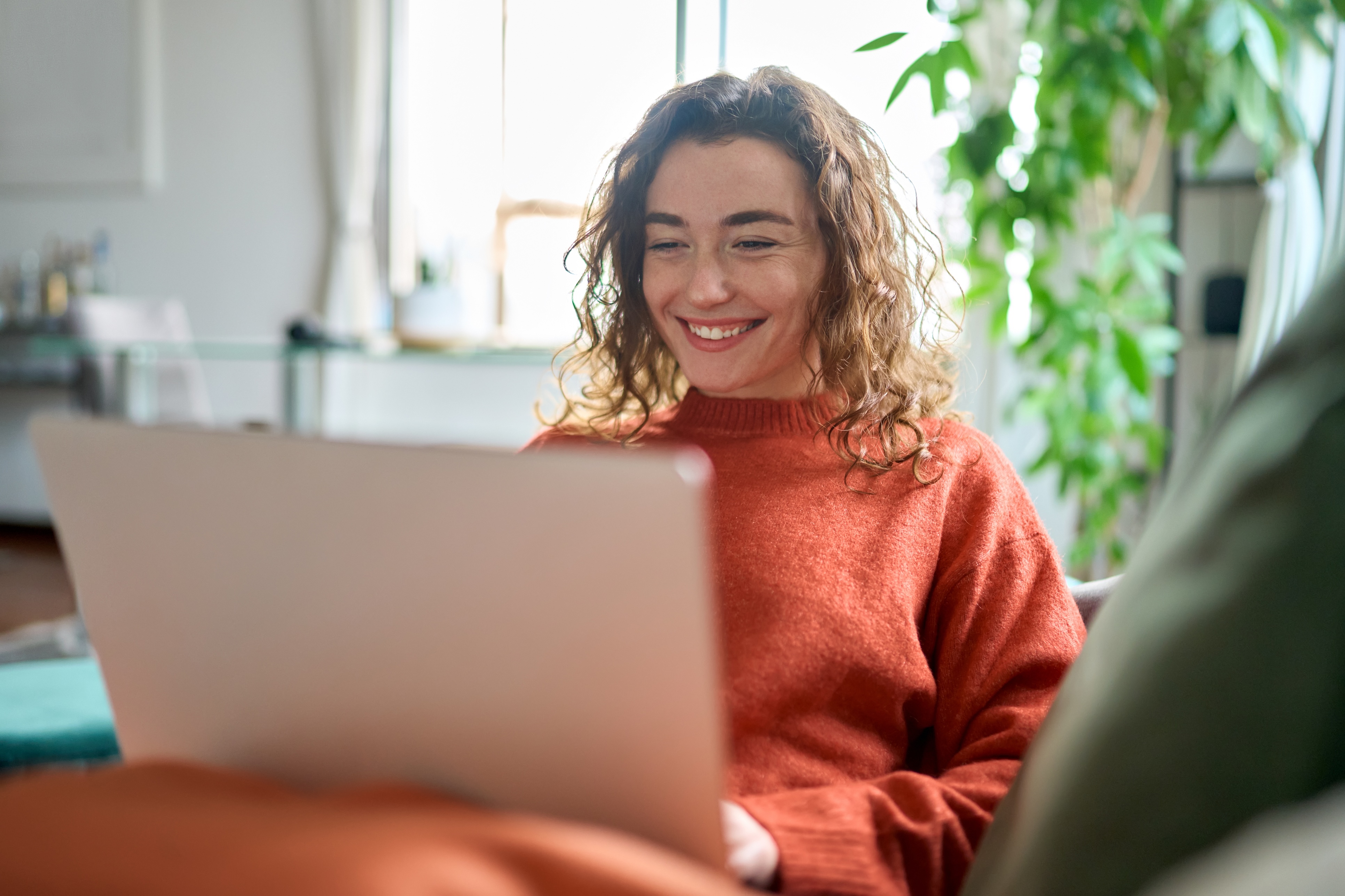 Glückliche Frau sitzt am Laptop