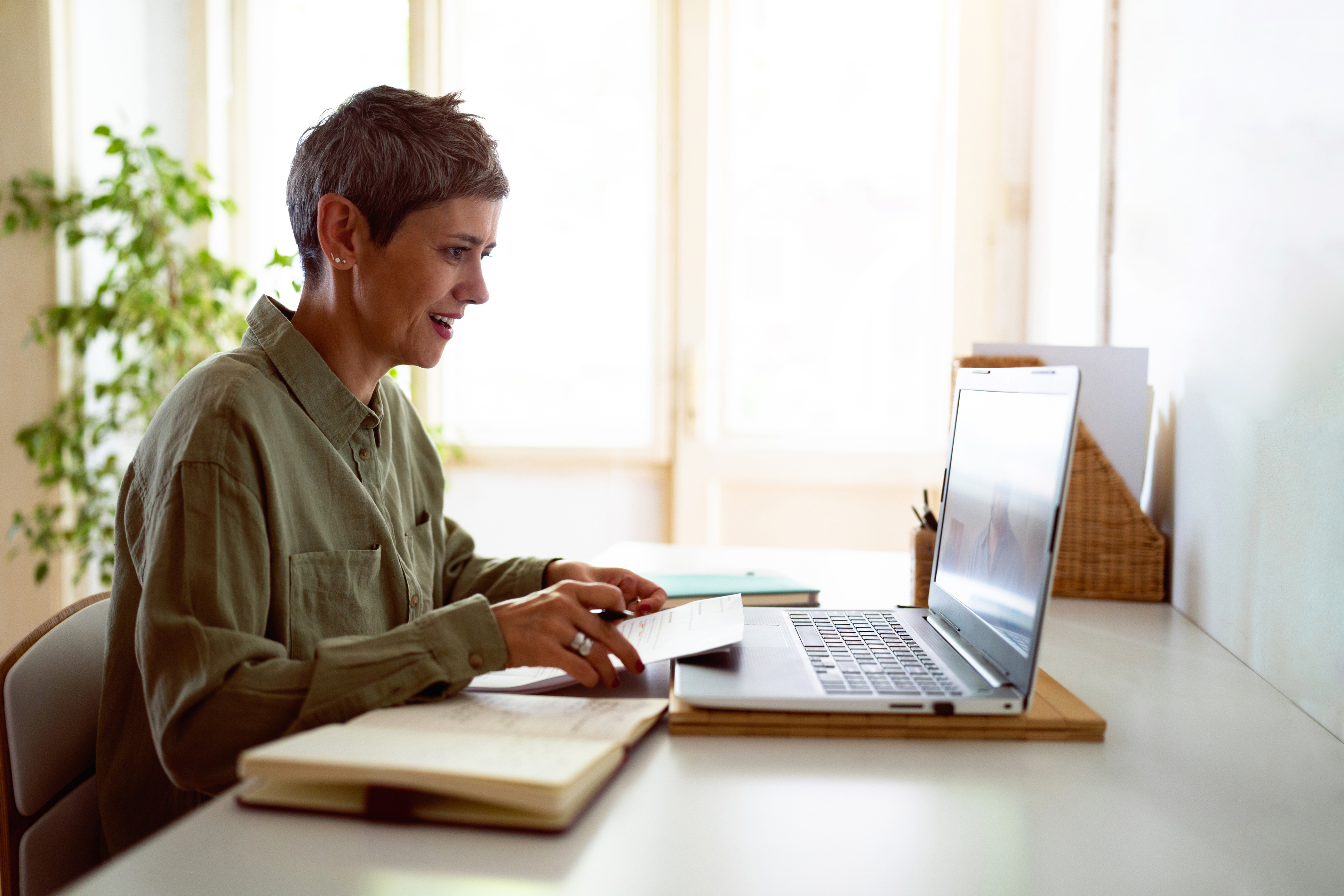Woman attends online courses on her laptop at home.