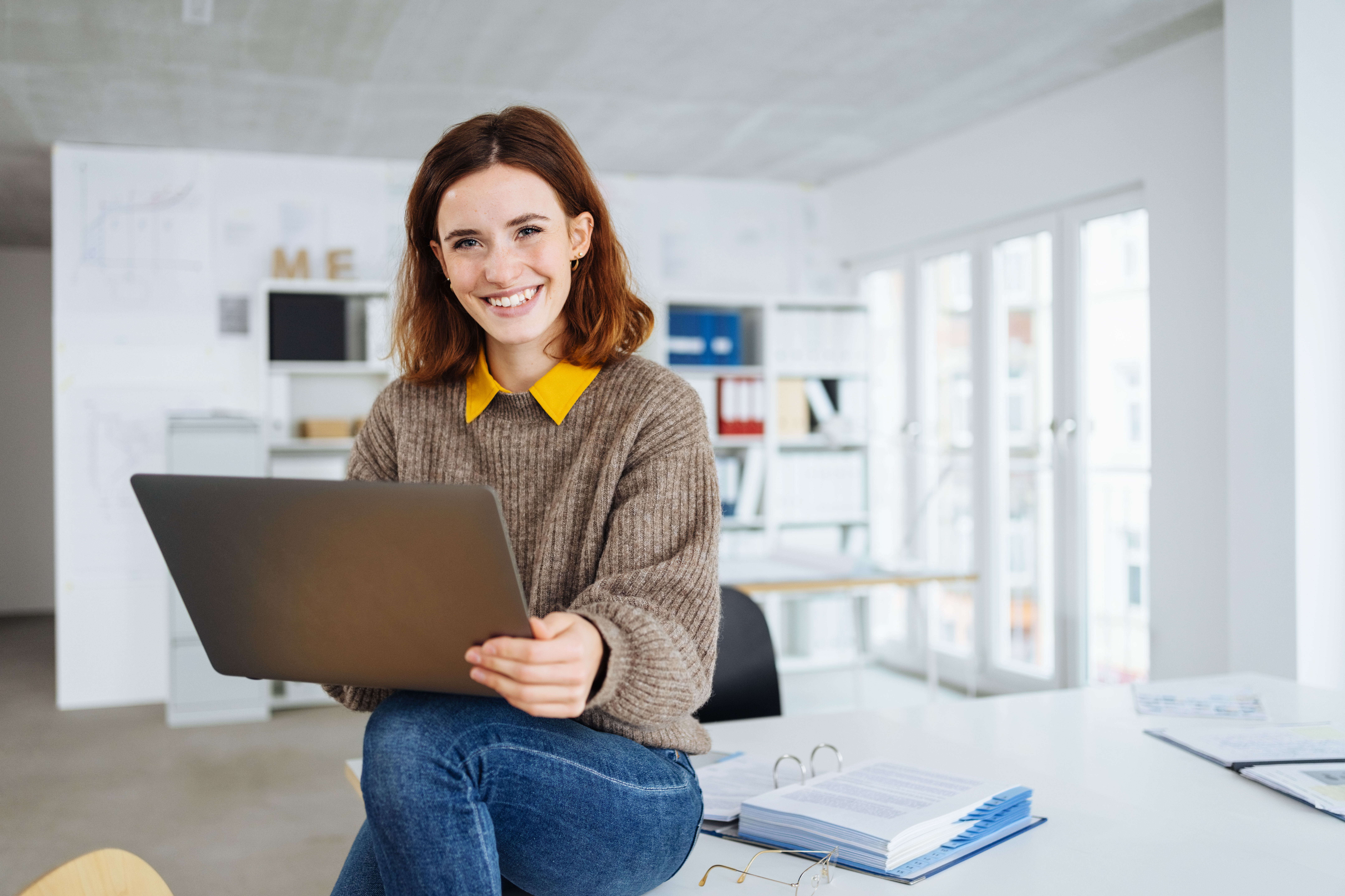 Smiling woman with laptop on her lap