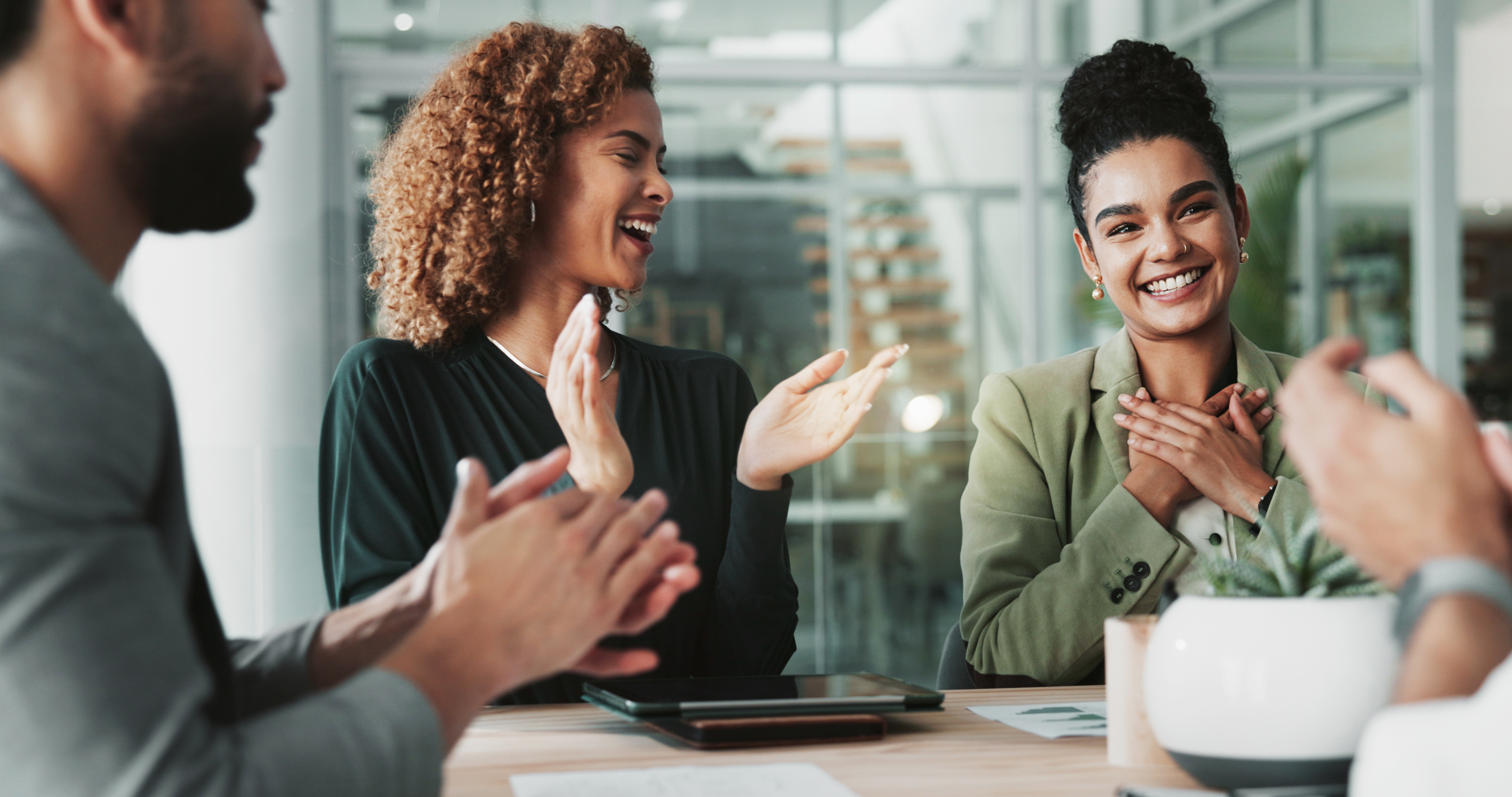 People in a meeting are happy together about a success
