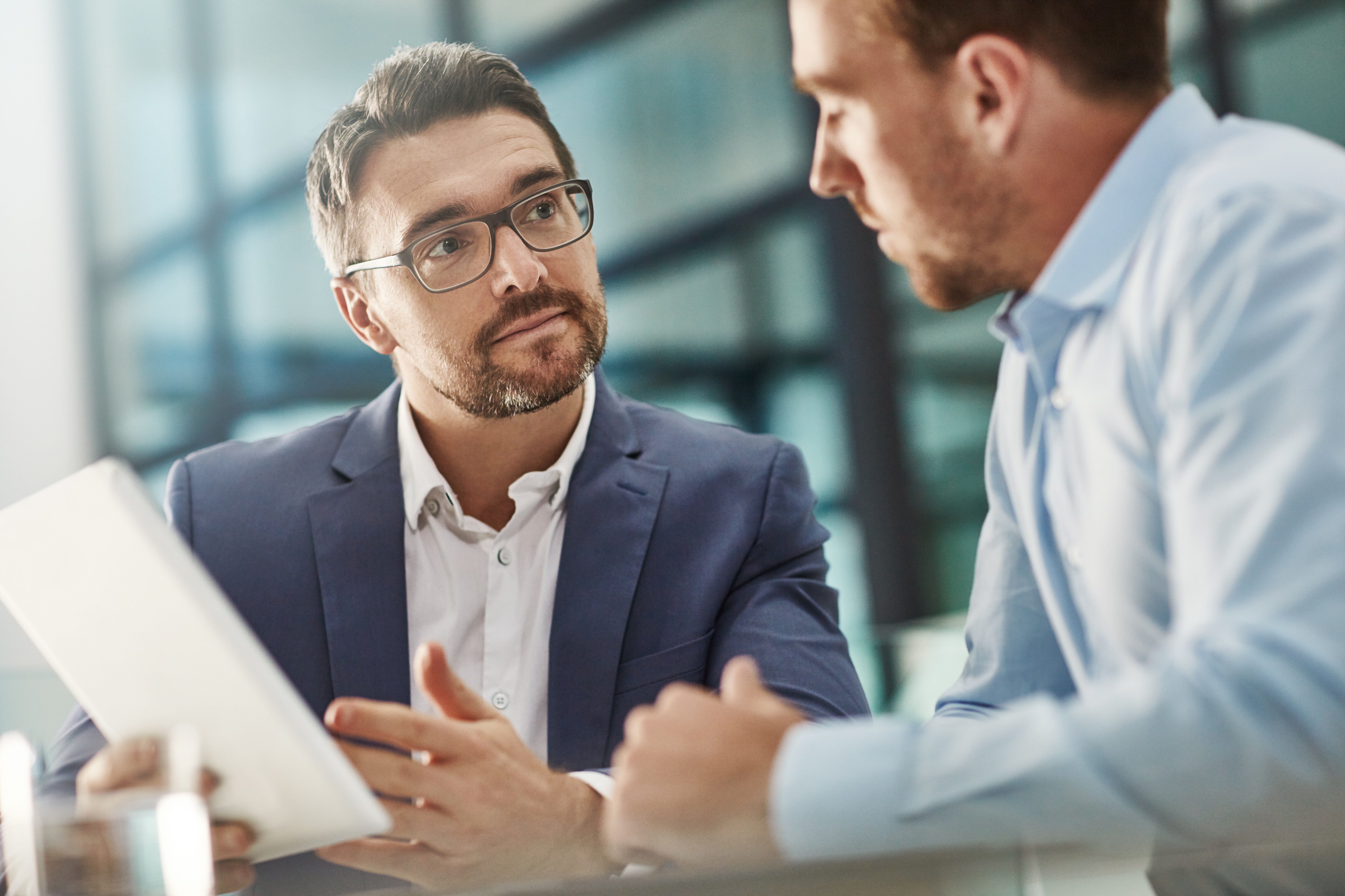 Two businessmen talking in front of a business building