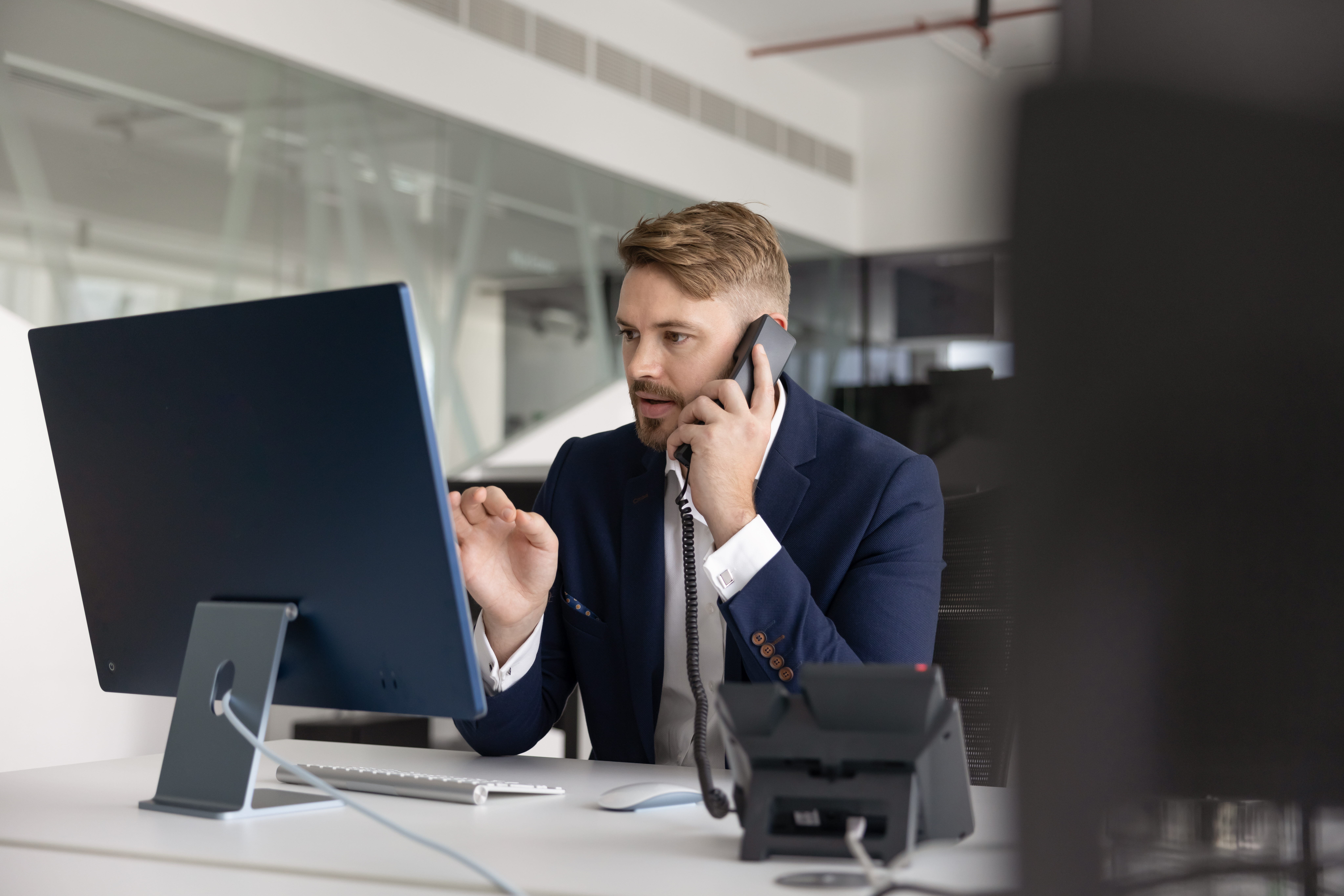 Mann vor Computer löst EVAC telefonisch aus